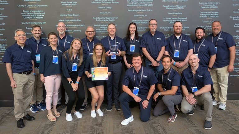 Large group of VHBers posing and smiling with a SAG Award certificate at the conference.