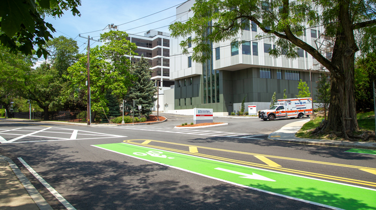A multistory gray hospital flanked by trees. 