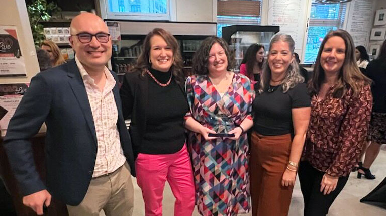 Four people stand with Jen McGovern for a group photo. 