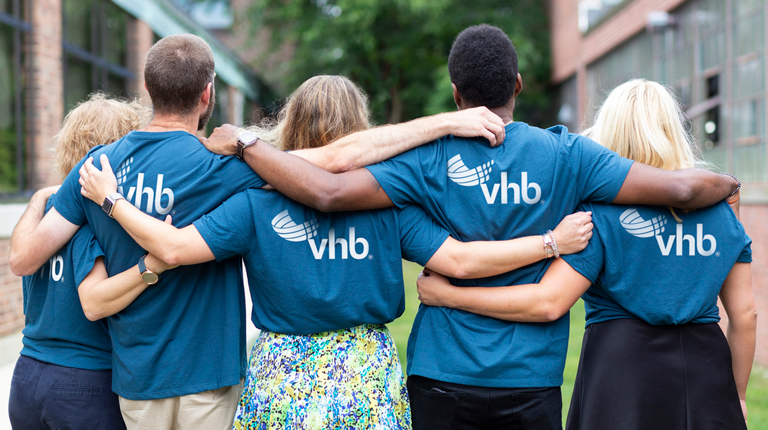 Employees embracing with blue VHB shirts.