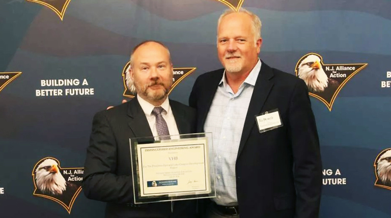 Two men holding an award