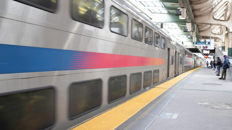 NJ TRANSIT train in motion at the station tracks. 