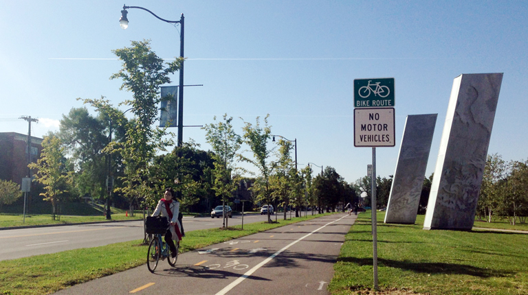 Woman biking along path in Buffalo, NY