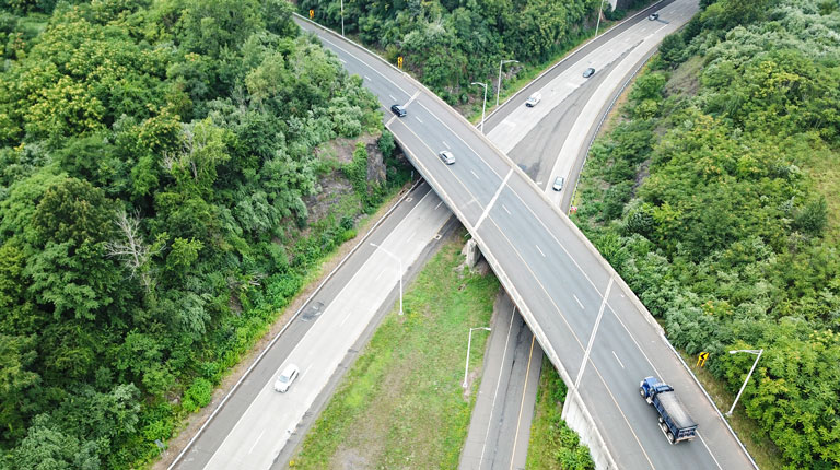 An aerial view of one of a bridge with roads running beneath it.