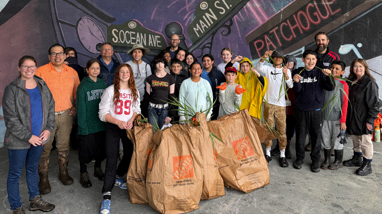 Group of adults and students smiling together. 