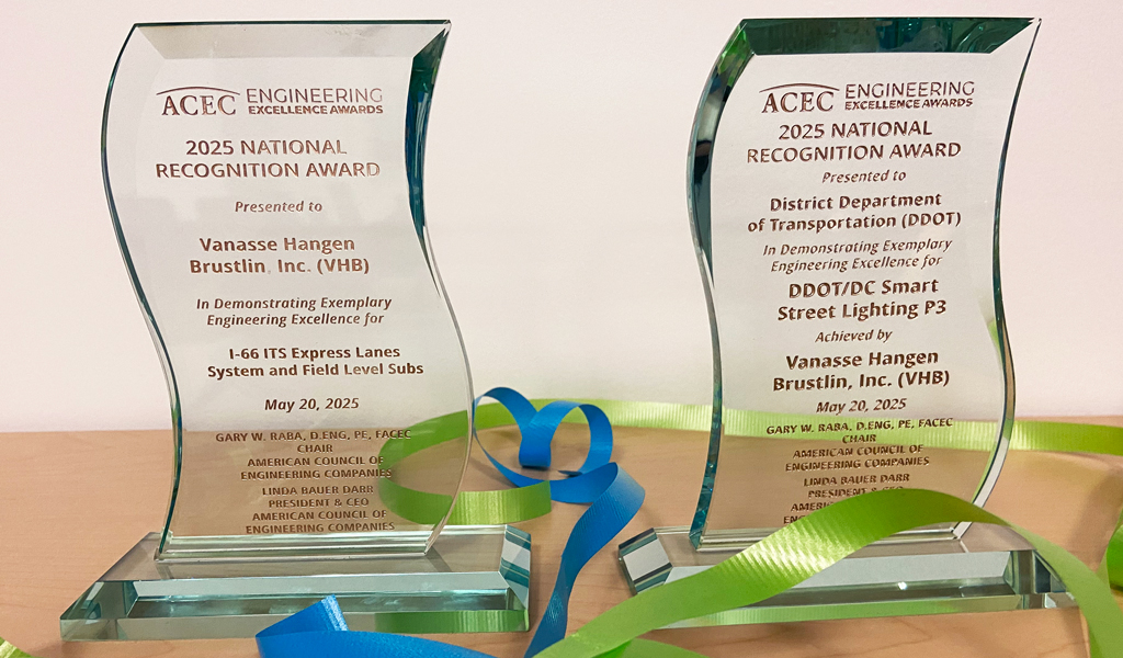 Two VHB projects awards sit on a table with celebratory ribbon. 