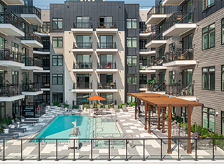 The pool and patio area surrounded on three sides by a modern residential 5-story building