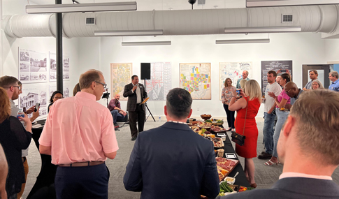 A group of people stand beside a refreshment table inside the new AIA Tampa Bay building 