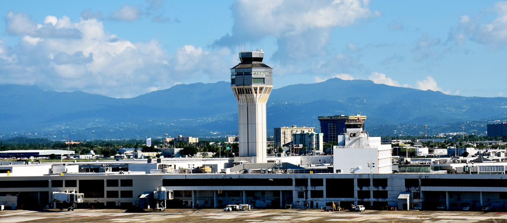 Airport a tower and mountains in the background.