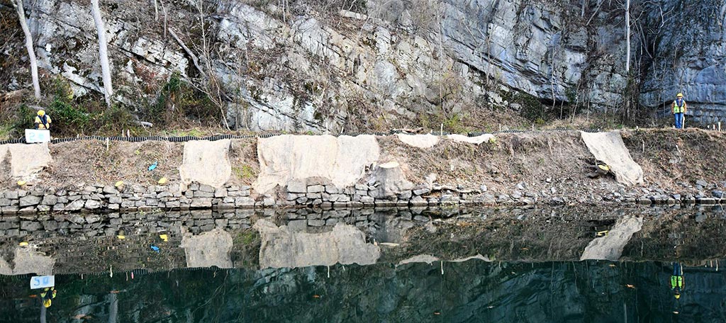 Before image shows deteriorated rock wall and river embankment.