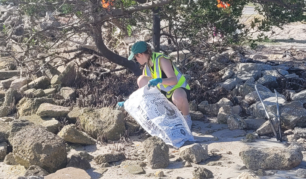 VHBer cleaning up marine debris along the rocky shoreline.