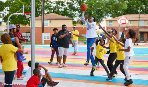 Residents playing basketball on the colorful courts.