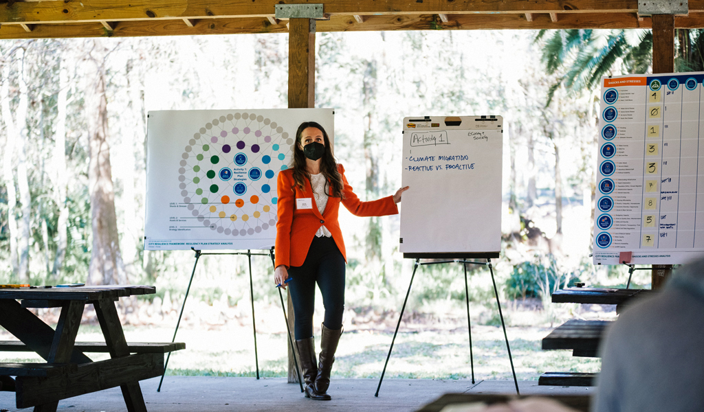 Katie leads an outdoor meeting in a park.