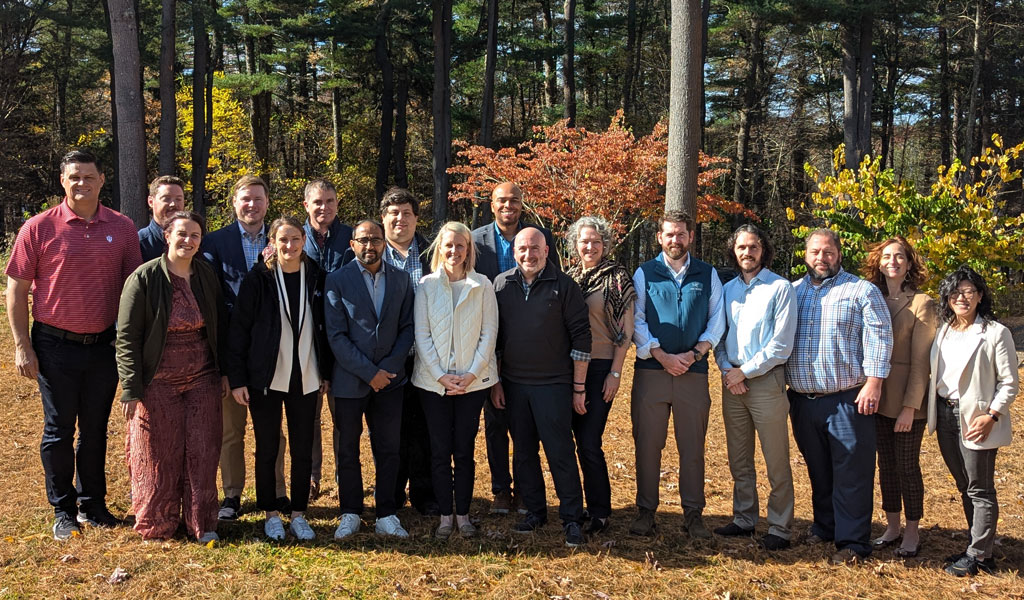 A group of seventeen LEADS participants and facilitators in business casual attire standing outside for a group photo.