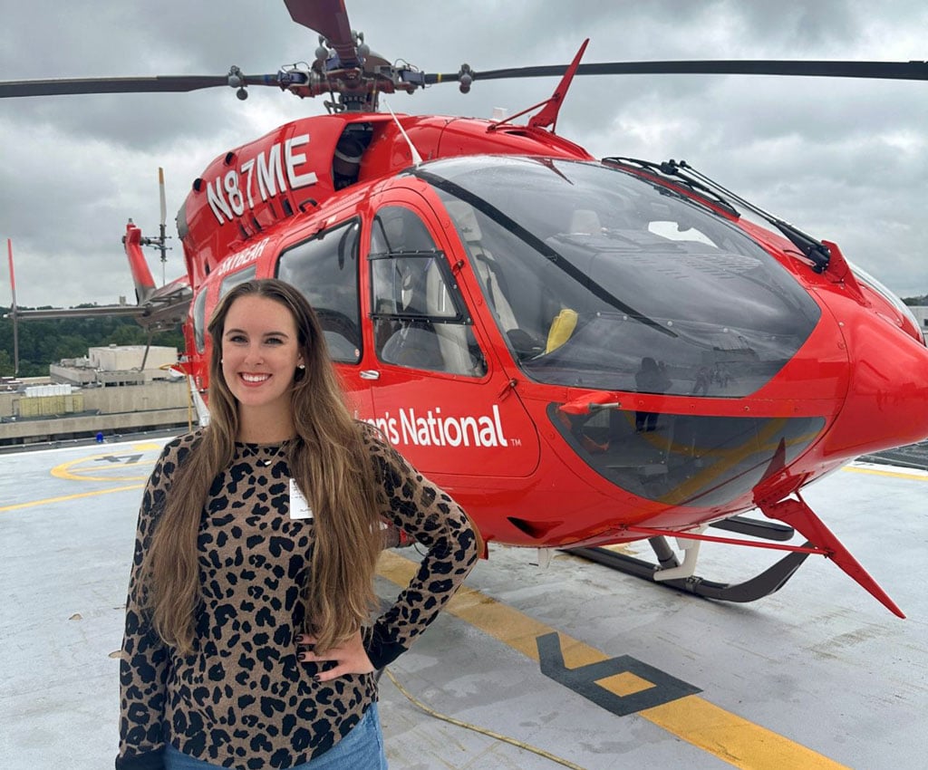 Marisa Blackwood standing outside in front of a red helicopter.