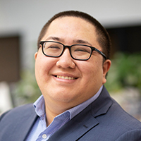 A person in a blue blazer and light-colored shirt.