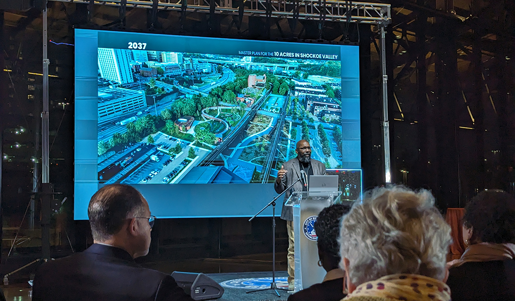 Audience view of a presenter at the podium talking about a 2037 Master Plan for an area of the Shockoe Valley  