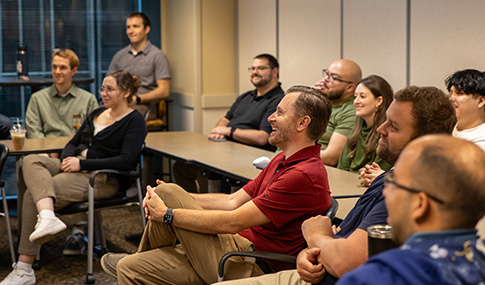 Group of employees watching a presentation made during a model-based workshop.