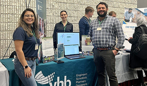 VHB team members stand at the company’s exhibit booth during an open house