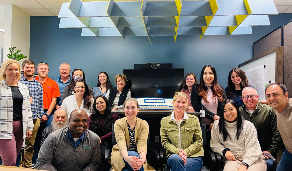 Approximately 16 Virginia Beach office employees assembled in a conference room for a group photo.