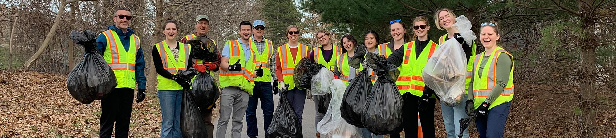 Several VHB volunteers displaying many bags of trash collected during localized cleanup efforts.