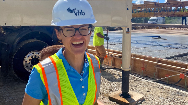 Olivia Richards in a VHB hard hat and safety vest, laughing at the camera