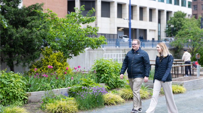 Gavin Graham and a teammate walking through downtown Boston during a collaborative discussion.