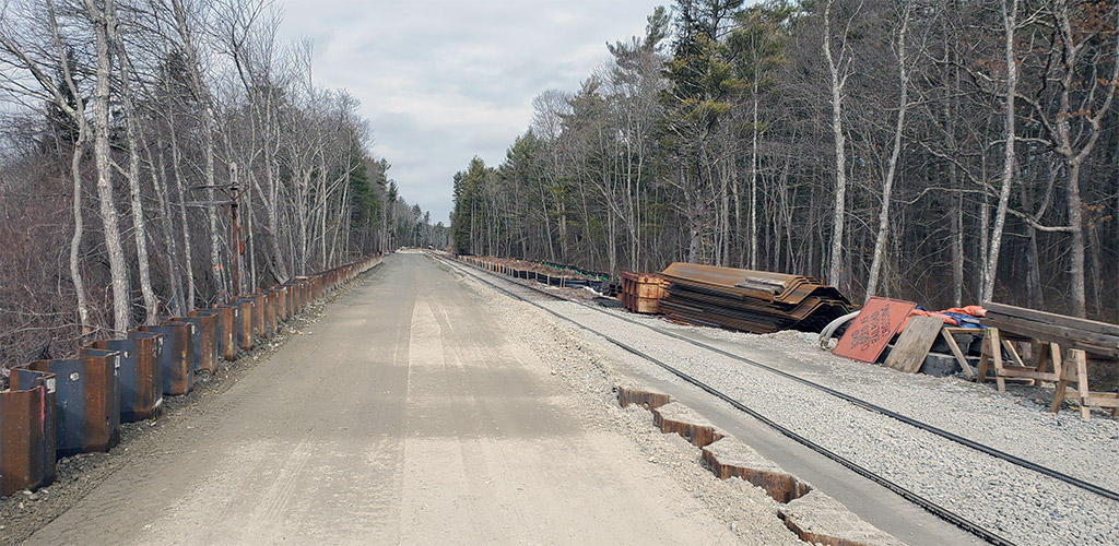 A bed of sand and rock being prepared for railroad tracks.