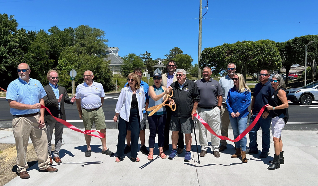 Project team members stand together to cut a red ribbon at the project’s grand opening.