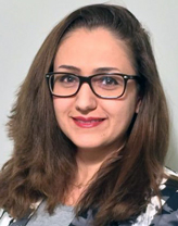 Mehri Mohebbi wearing glasses in an office setting. 