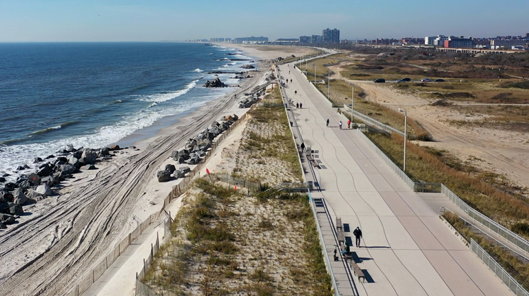 Aerial view of a beach and walkway. 