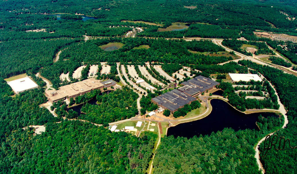 An aerial view of a development amidst forested areas. 