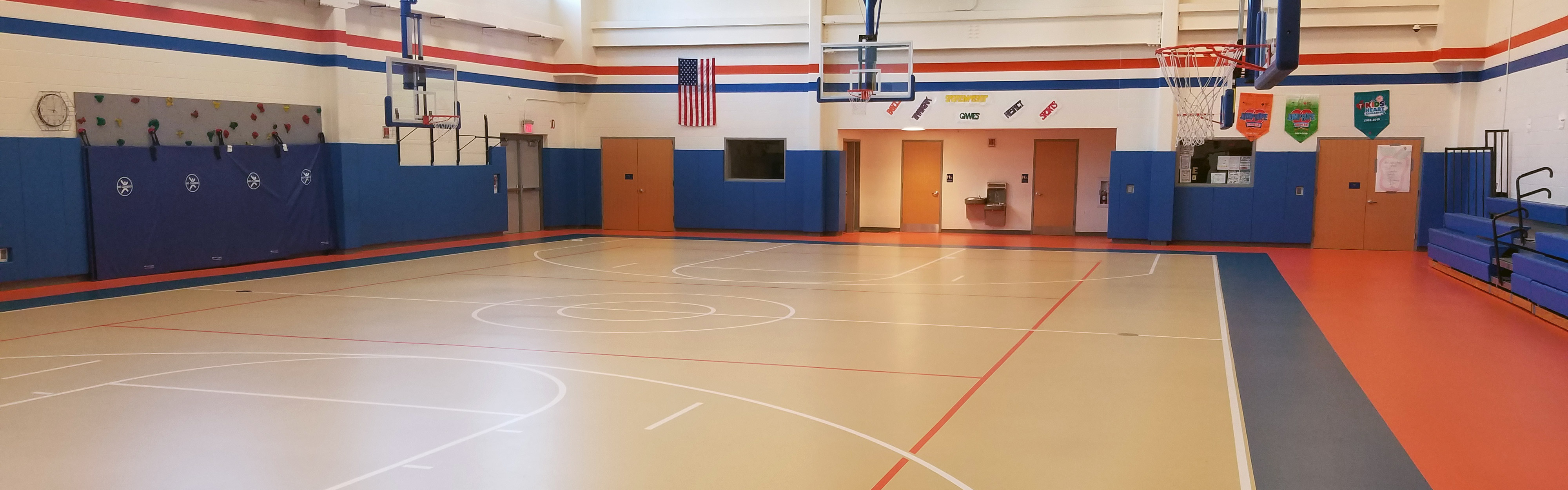 Gymnasium with multi-colored floor and blue, padded walls.