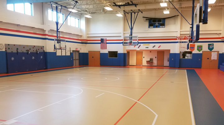 Gymnasium with multi-colored floor and blue, padded walls.