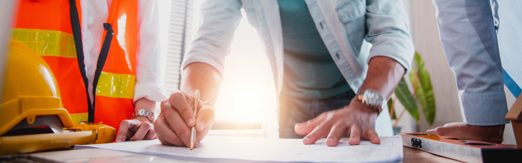 Three people representing contractor, designer, and owner collaborate on project plans.