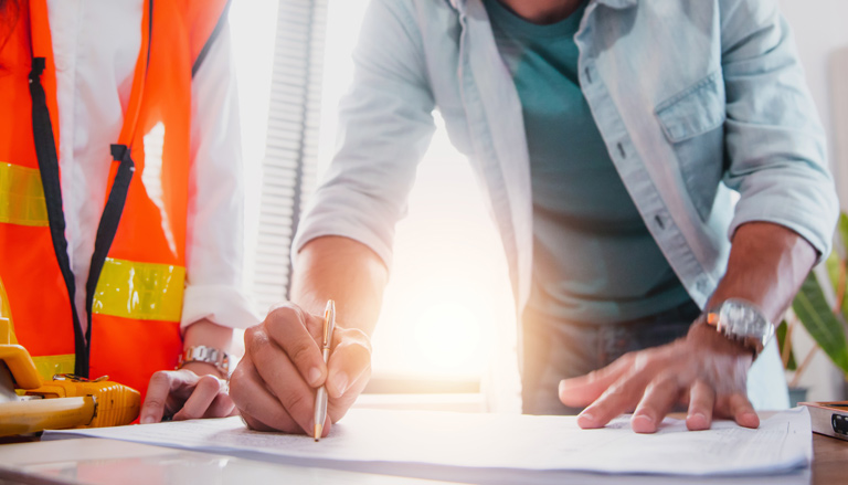 Three people representing contractor, designer, and owner collaborate on project plans. 