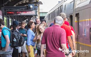 People board and deboard a train at a crowded station